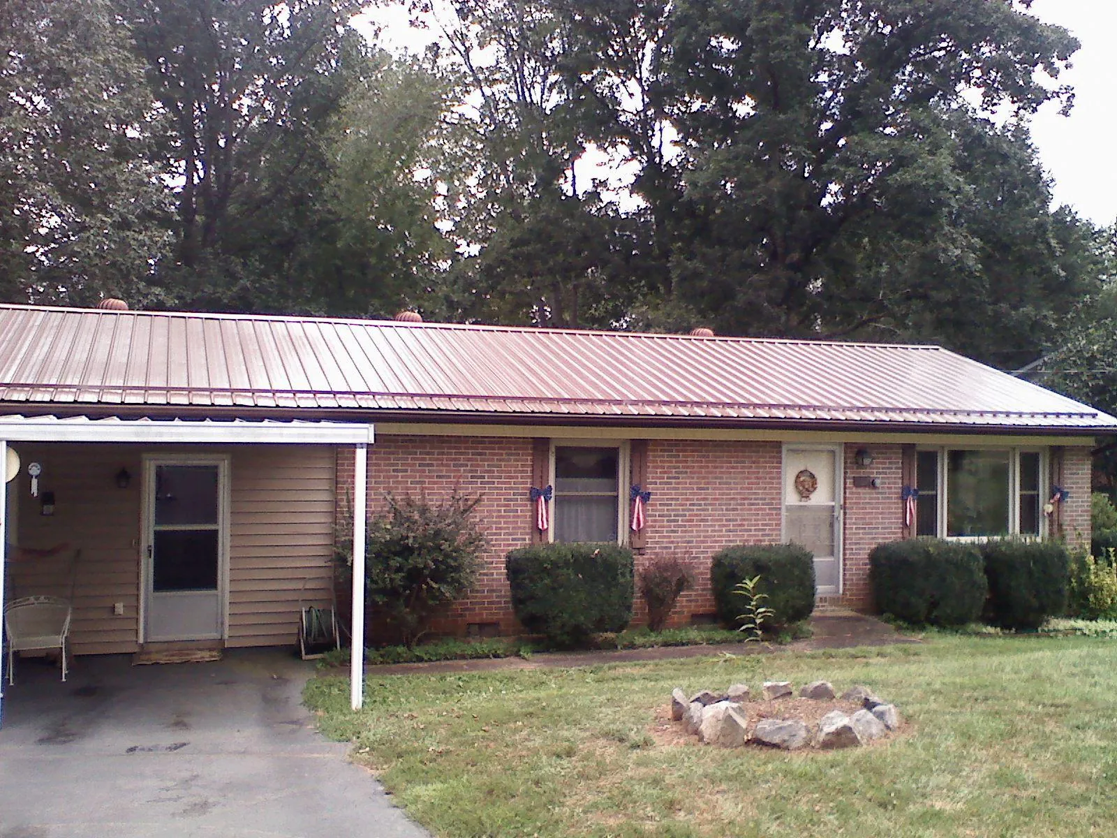 Bronze metal roof and carport on a brick ranch home — Roof Repair work by our crew in Gray